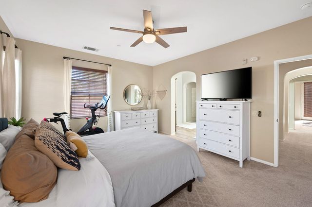 a bedroom with a bed a flat screen tv and dresser