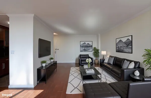 a living room with furniture a flat screen tv and a window
