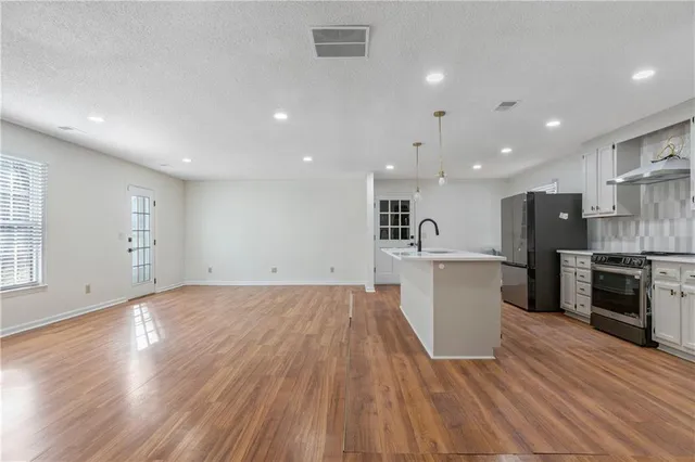 a view of kitchen with sink and refrigerator