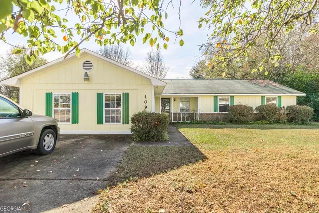 a view of a house with backyard and garden