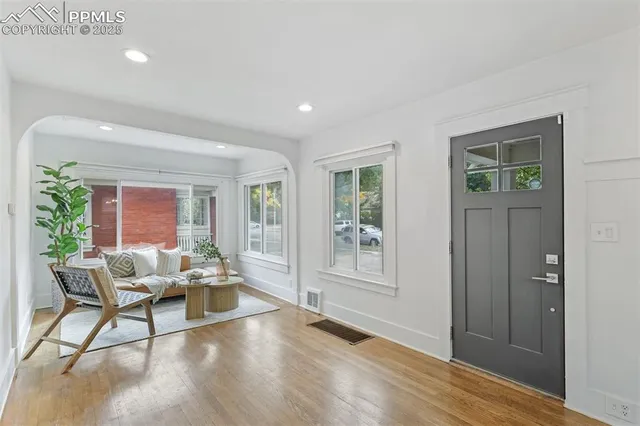 a dining room with wooden floor a glass table and chairs