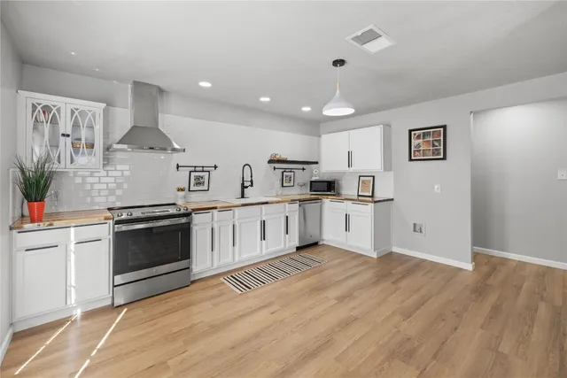 a large kitchen with stainless steel appliances granite countertop a stove and a sink