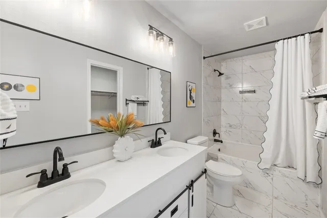 a bathroom with a double vanity sink mirror double and shower