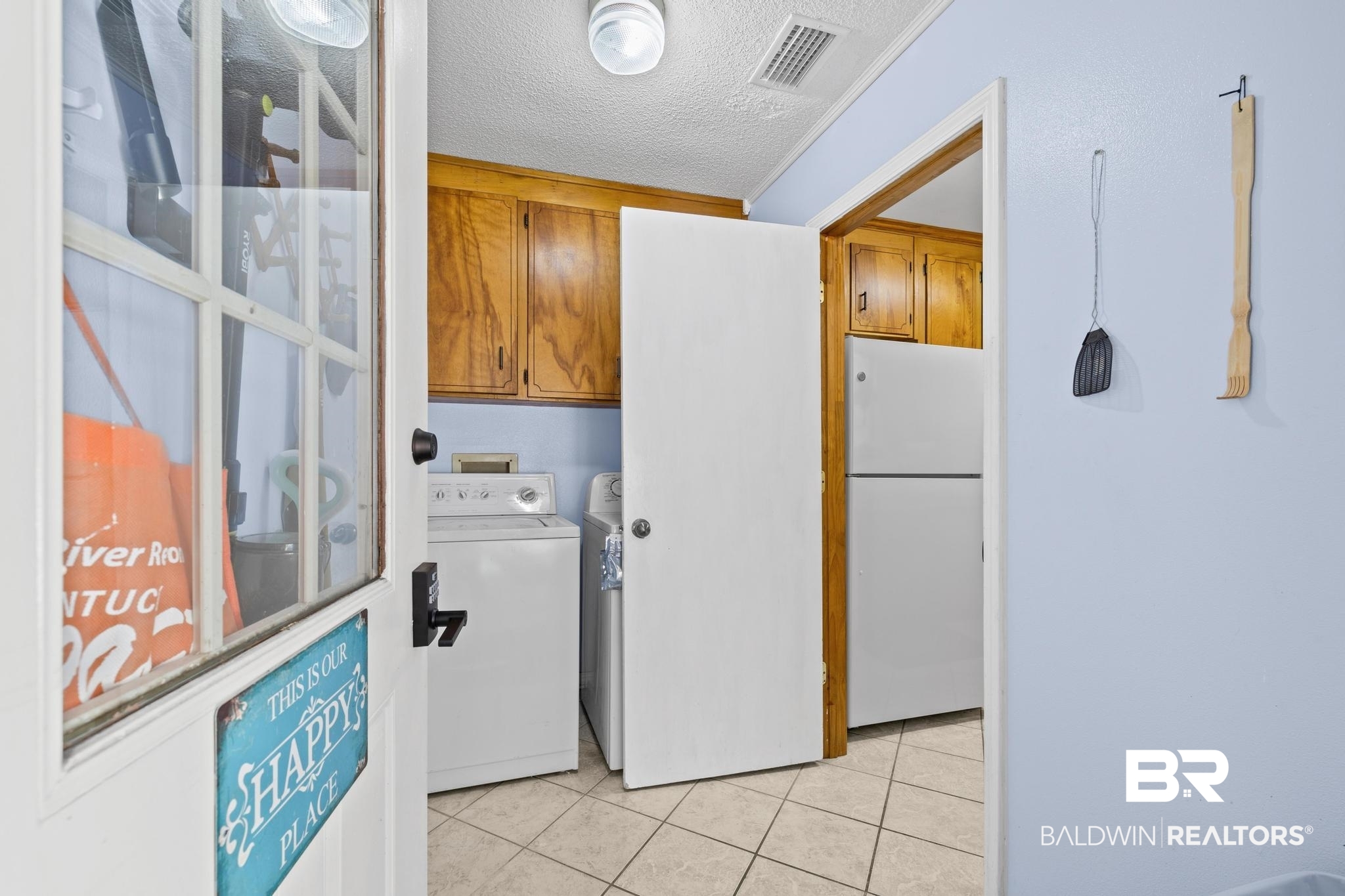 1437 Rio Circle Lillian, AL 36549 - Photo 3 of 46 Laundry room with a textured ceiling, washer / dryer, cabinet space, and light tile patterned floors