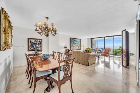 a dining room with furniture a rug and a chandelier