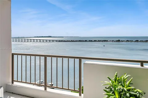 a living room with a rug and a potted plant