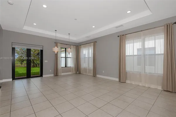 a view of an empty room with window and stairs
