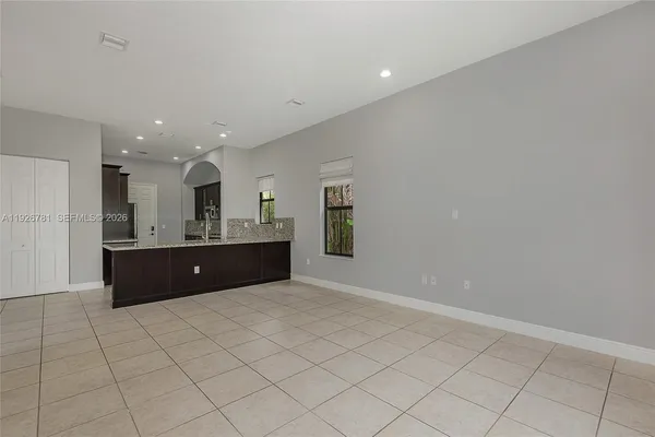 a large kitchen with stainless steel appliances a large counter top a refrigerator and a sink