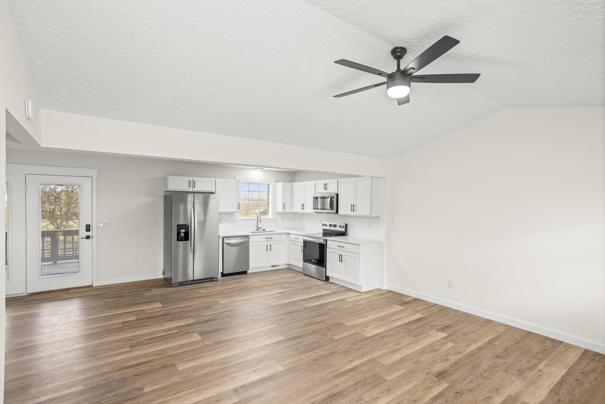 1053 Johns Road Joelton, TN 37080 - Photo 7 of 83 a view of a kitchen with wooden floor and a ceiling fan
