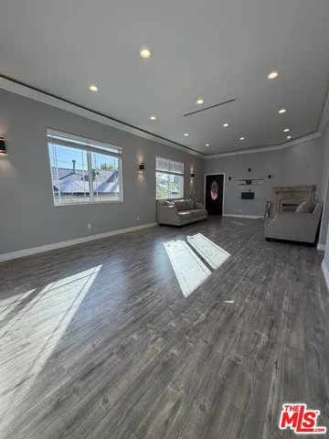 an empty room with kitchen view and a window