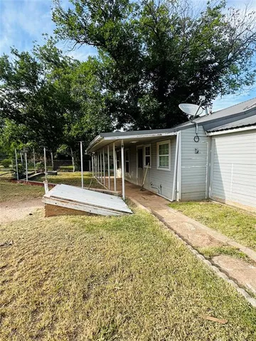 a view of a house with a backyard and a tree
