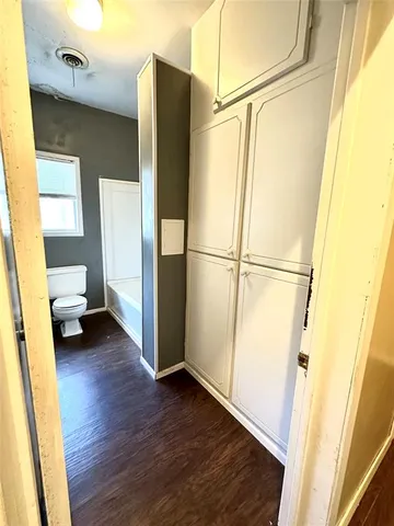 a view of walk in closet with wooden floor and door