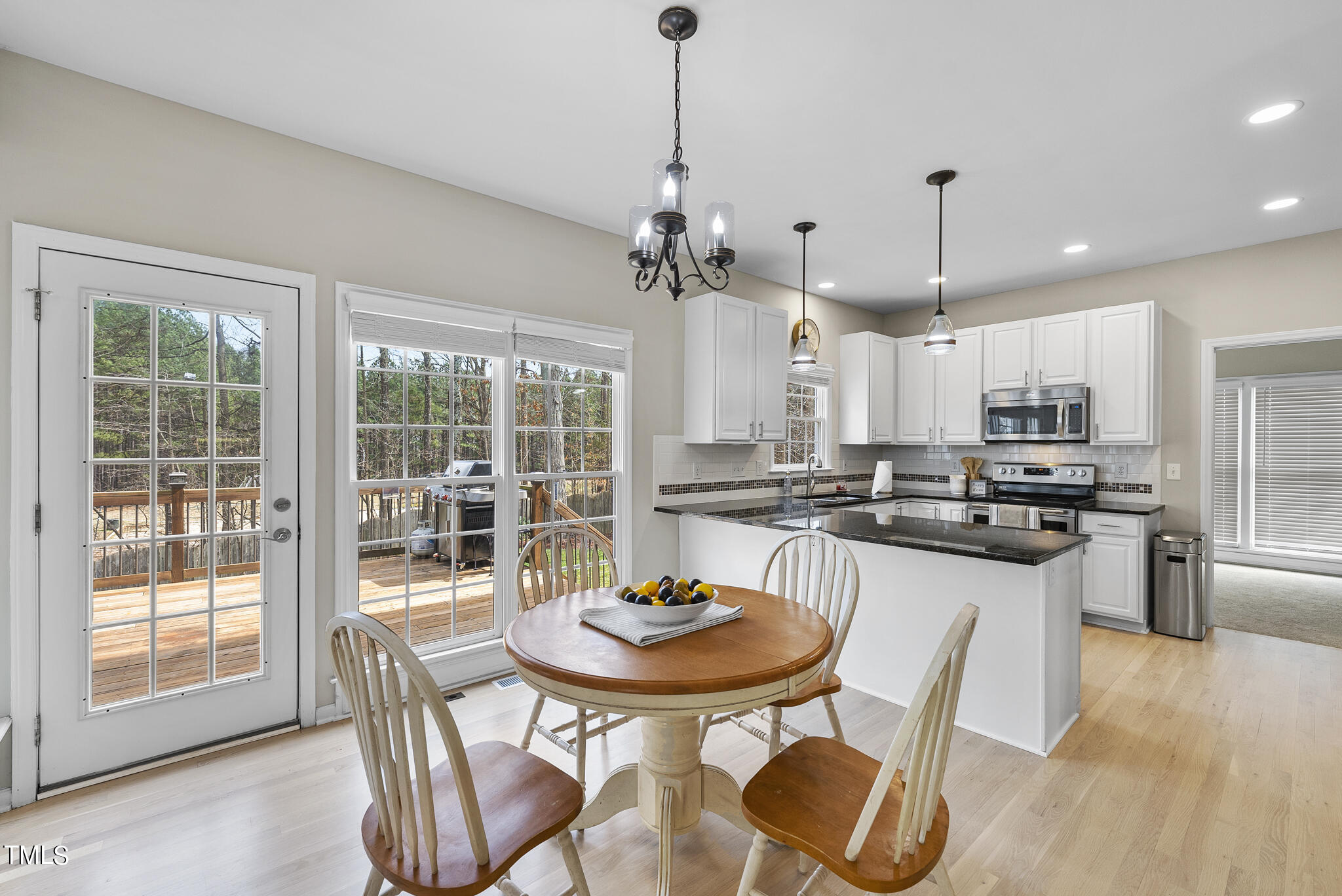 9013 Miranda Drive Raleigh, NC 27617 - Photo 12 of 41 a kitchen with stainless steel appliances granite countertop a dining table chairs and white cabinets