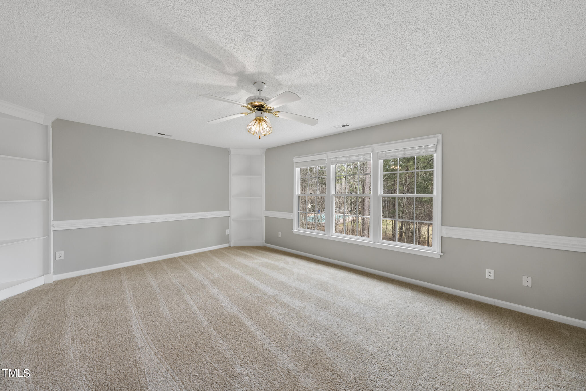 9013 Miranda Drive Raleigh, NC 27617 - Photo 20 of 41 an empty room with windows and chandelier fan