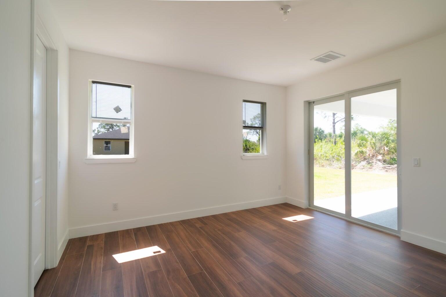 15061 Brainbridge Circle Port Charlotte, FL 33981 - Photo 12 of 21 a view of an empty room with wooden floor and a window