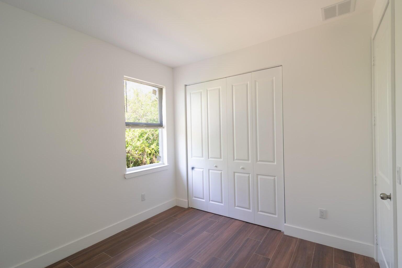 15061 Brainbridge Circle Port Charlotte, FL 33981 - Photo 16 of 21 an empty room with wooden floor and windows