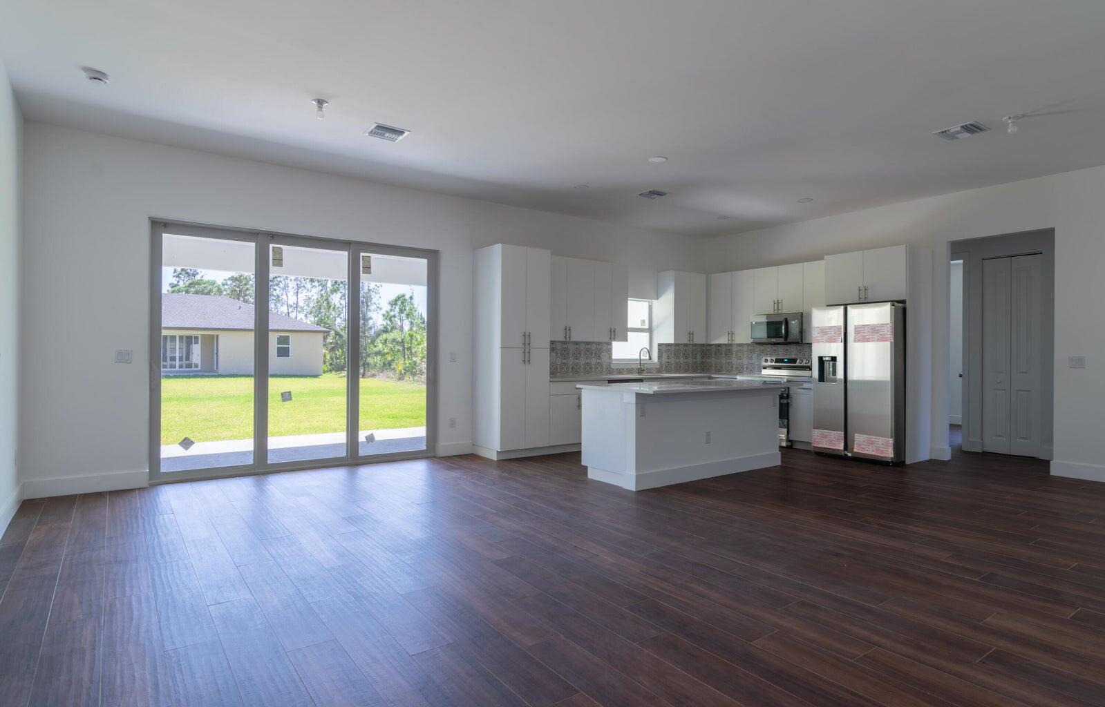 15061 Brainbridge Circle Port Charlotte, FL 33981 - Photo 4 of 21 a view of an empty room with window and wooden floor