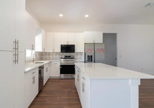 a kitchen with a sink a stove top oven and white kitchen
