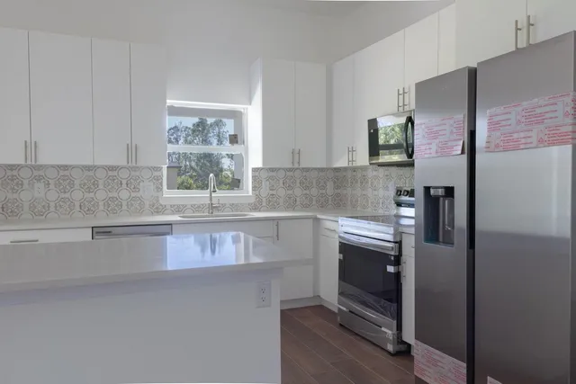 a kitchen with stainless steel appliances granite countertop a refrigerator and a sink