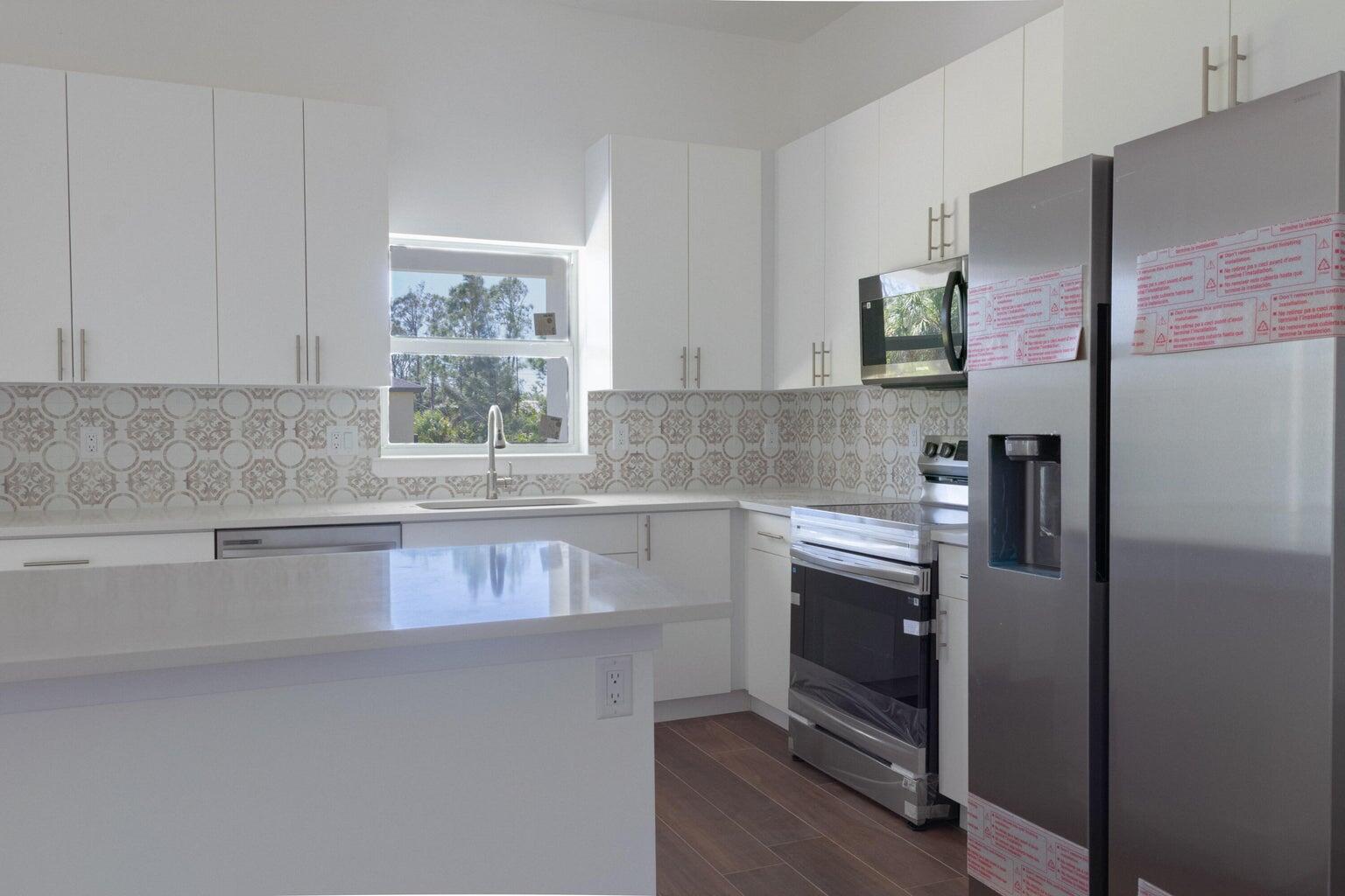 15061 Brainbridge Circle Port Charlotte, FL 33981 - Photo 7 of 21 a kitchen with stainless steel appliances granite countertop a refrigerator and a sink