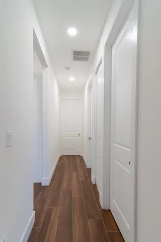 a view of a hallway with wooden floor
