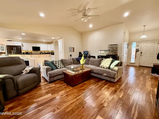 a living room with furniture and a wooden floor