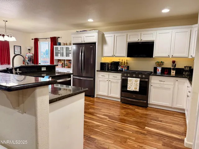 a kitchen with granite countertop a sink stove and refrigerator