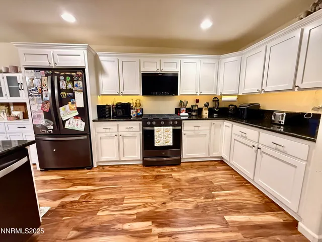 a kitchen with stainless steel appliances kitchen island granite countertop a stove top oven a sink a counter space and cabinets