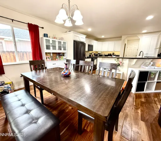 a view of a dining room with furniture a chandelier and wooden floor
