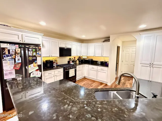 a kitchen with stainless steel appliances granite countertop a refrigerator sink and cabinets