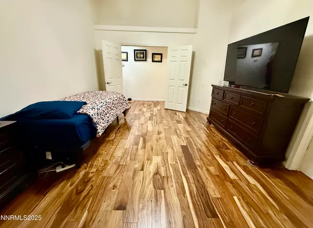a bedroom with a bed and a flat tv screen on dresser