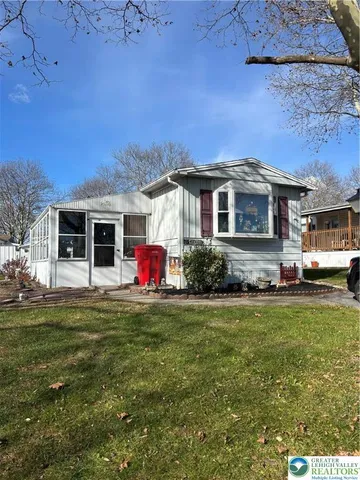 a front view of a house with a garden and yard