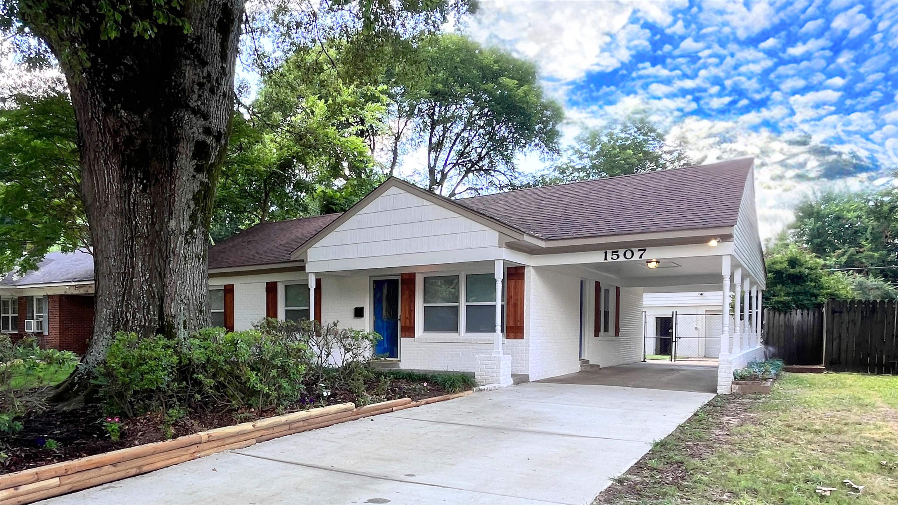 1507 Flamingo Road Memphis, TN 38117 - Photo 1 of 29 a front view of a house with a garden and trees