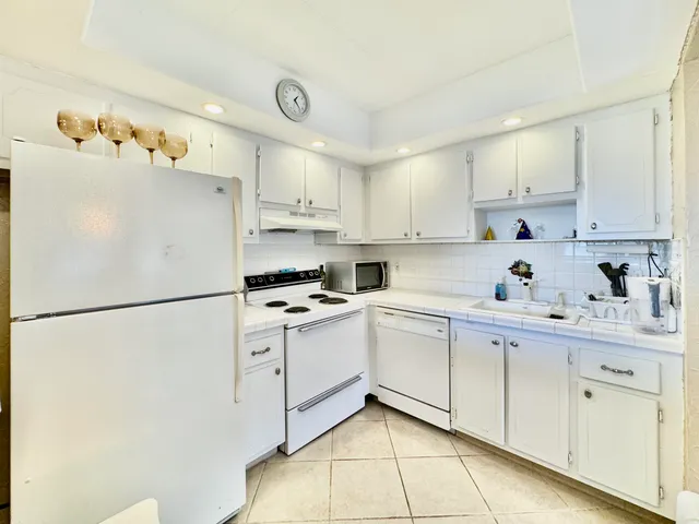 a kitchen with cabinets stainless steel appliances and a refrigerator
