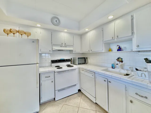 a kitchen with a white cabinets and white appliances