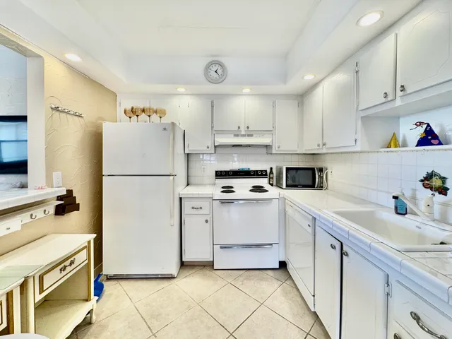 a kitchen with a refrigerator sink stove and cabinets