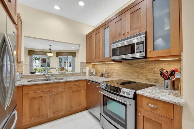 a kitchen with stainless steel appliances granite countertop a sink stove and microwave