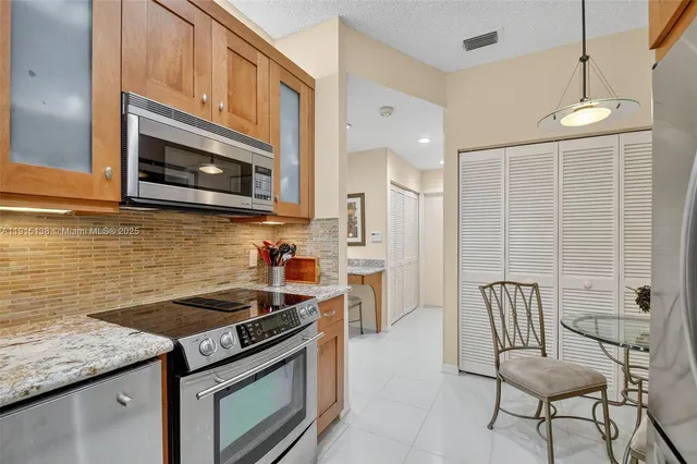 a kitchen with stainless steel appliances granite countertop a stove and a microwave