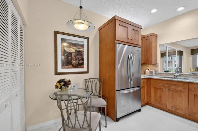 a kitchen with stainless steel appliances granite countertop a refrigerator and a sink
