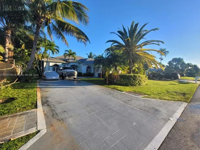 front view of house with a yard and potted plants