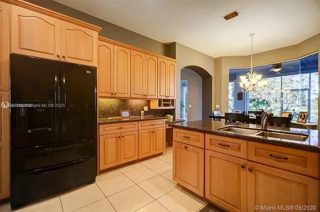 a kitchen with stainless steel appliances granite countertop a refrigerator and a sink
