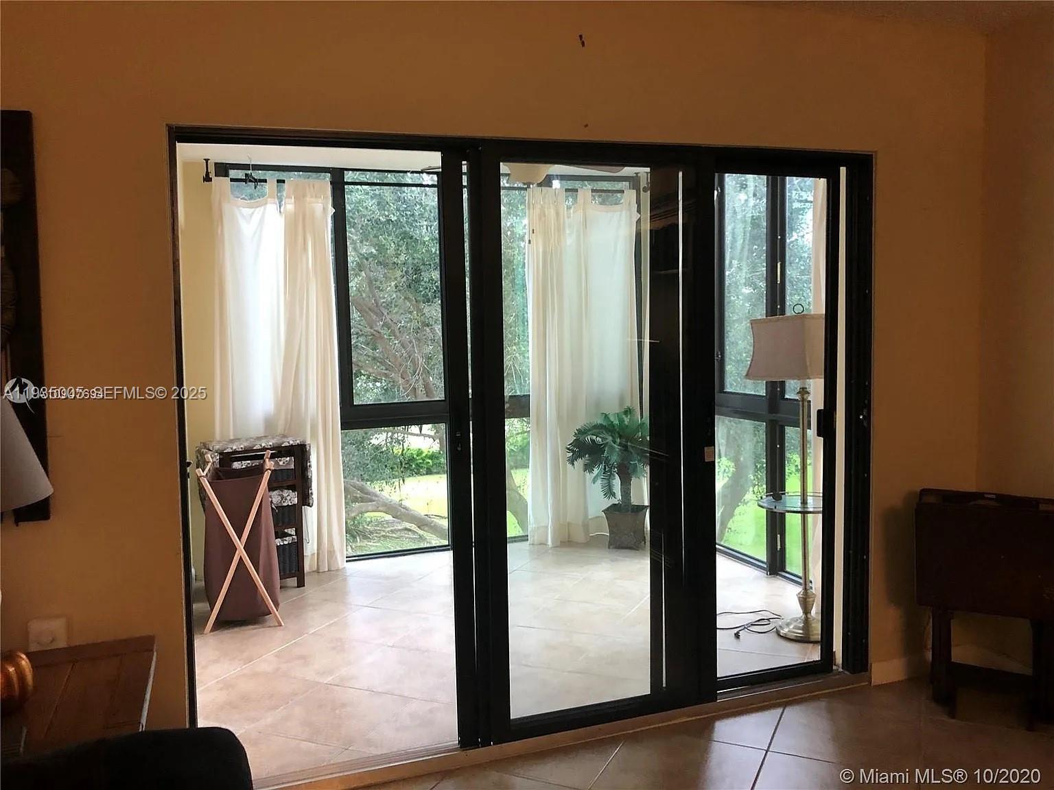 9440 Southwest 8th Street, Unit 402 Boca Raton, FL 33428 - Photo 14 of 19 a view of a glass door with a dining room and glass door