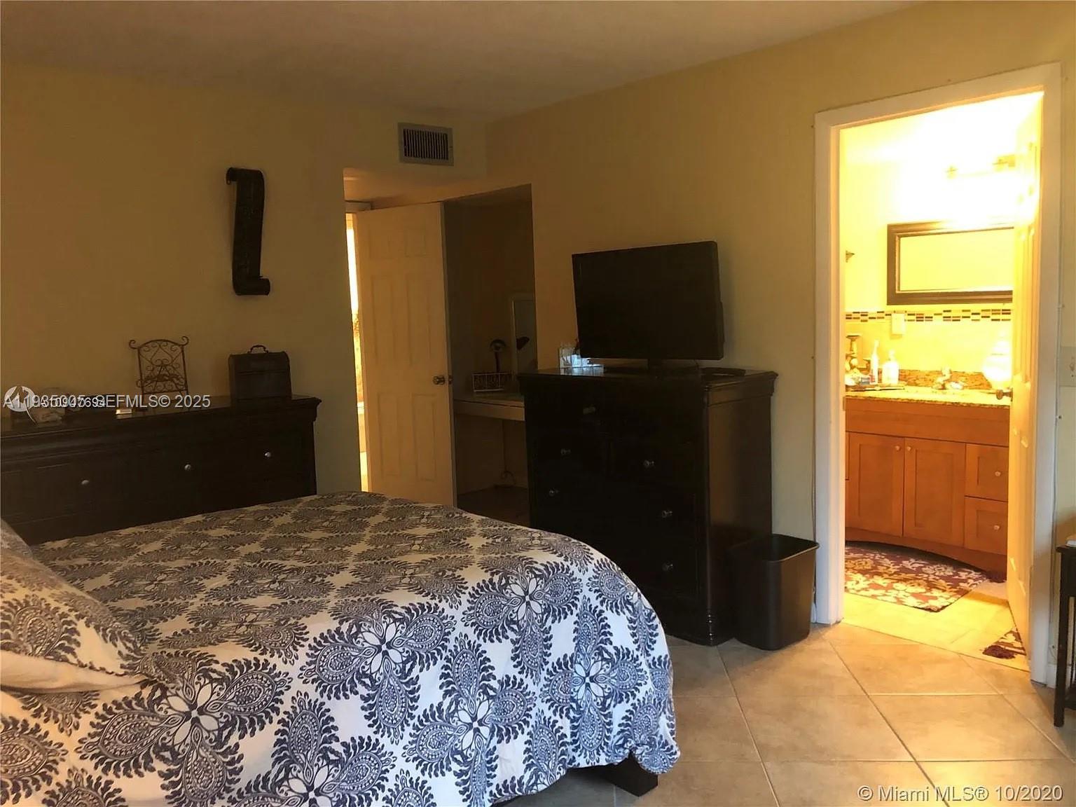 9440 Southwest 8th Street, Unit 402 Boca Raton, FL 33428 - Photo 5 of 19 a bedroom with a bed and a television