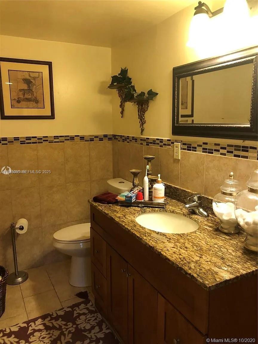 9440 Southwest 8th Street, Unit 402 Boca Raton, FL 33428 - Photo 7 of 19 a bathroom with a granite countertop sink and a mirror