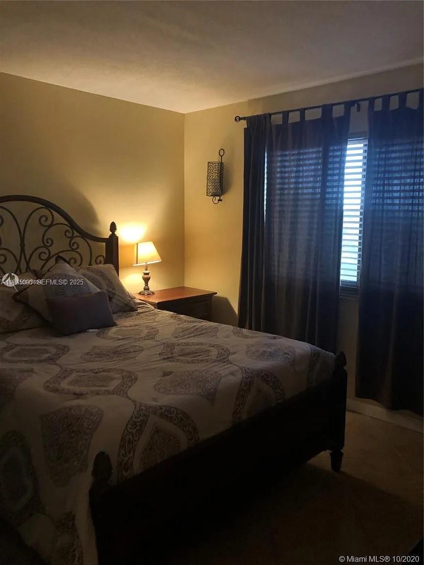 9440 Southwest 8th Street, Unit 402 Boca Raton, FL 33428 - Photo 8 of 19 a bedroom with a bed and a window