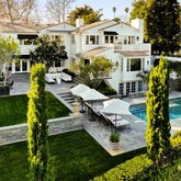 a view of a house with swimming pool lawn chairs and a yard