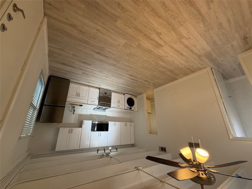 2408 Leon Street, Unit 218A Austin, TX 78705 - Photo 3 of 5 a kitchen with stainless steel appliances a refrigerator stove microwave and cabinets
