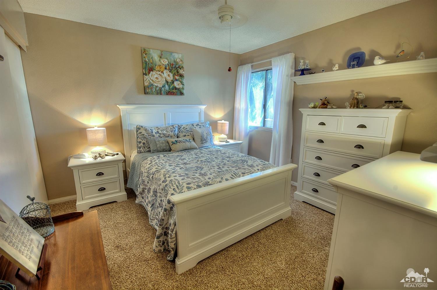 47395 Monroe Street, Unit 191 Indio, CA 92201 - Photo 12 of 21 a bedroom with a bed and a couch