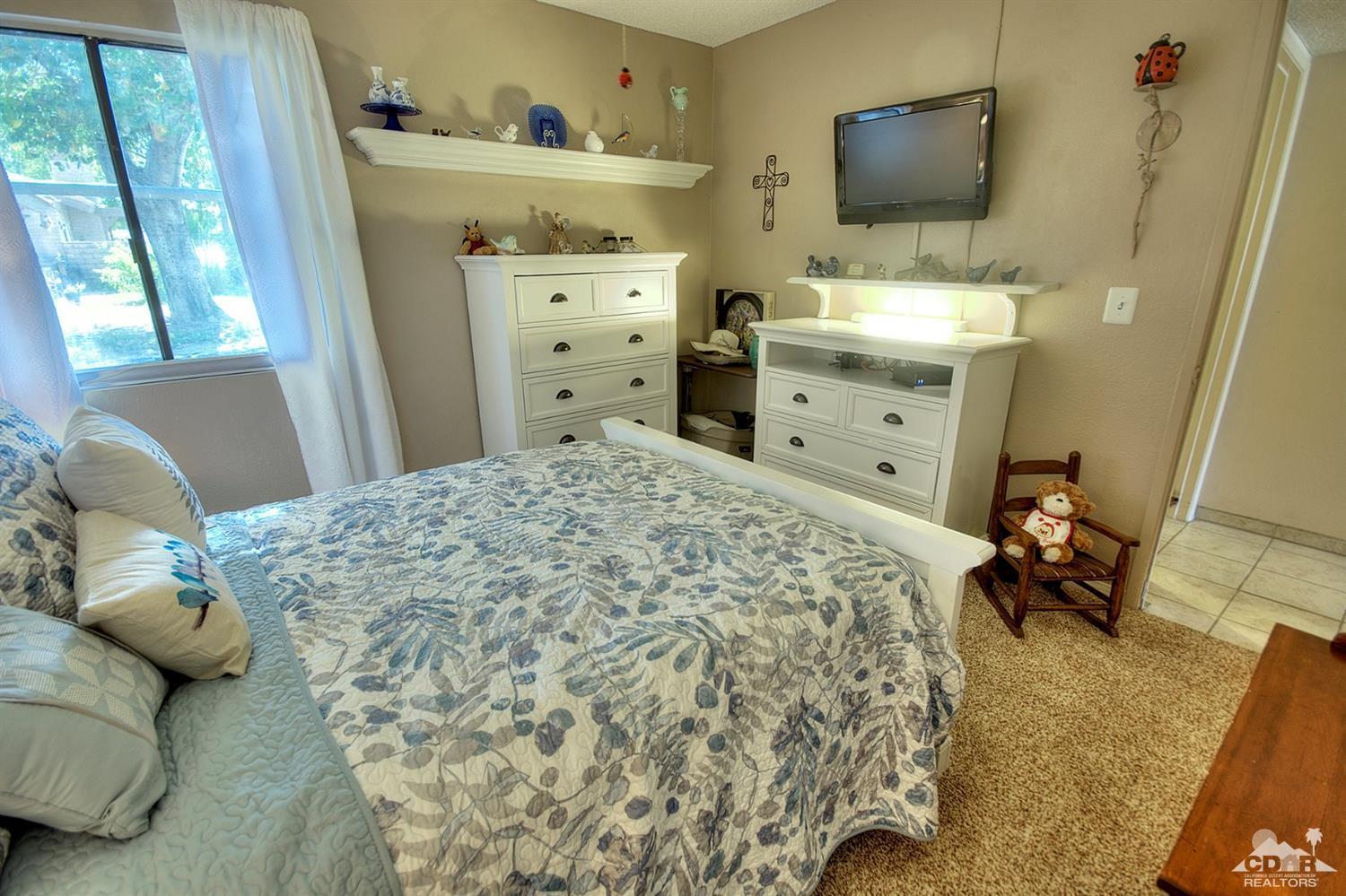 47395 Monroe Street, Unit 191 Indio, CA 92201 - Photo 13 of 21 a bedroom with a bed and flat tv screen on dresser