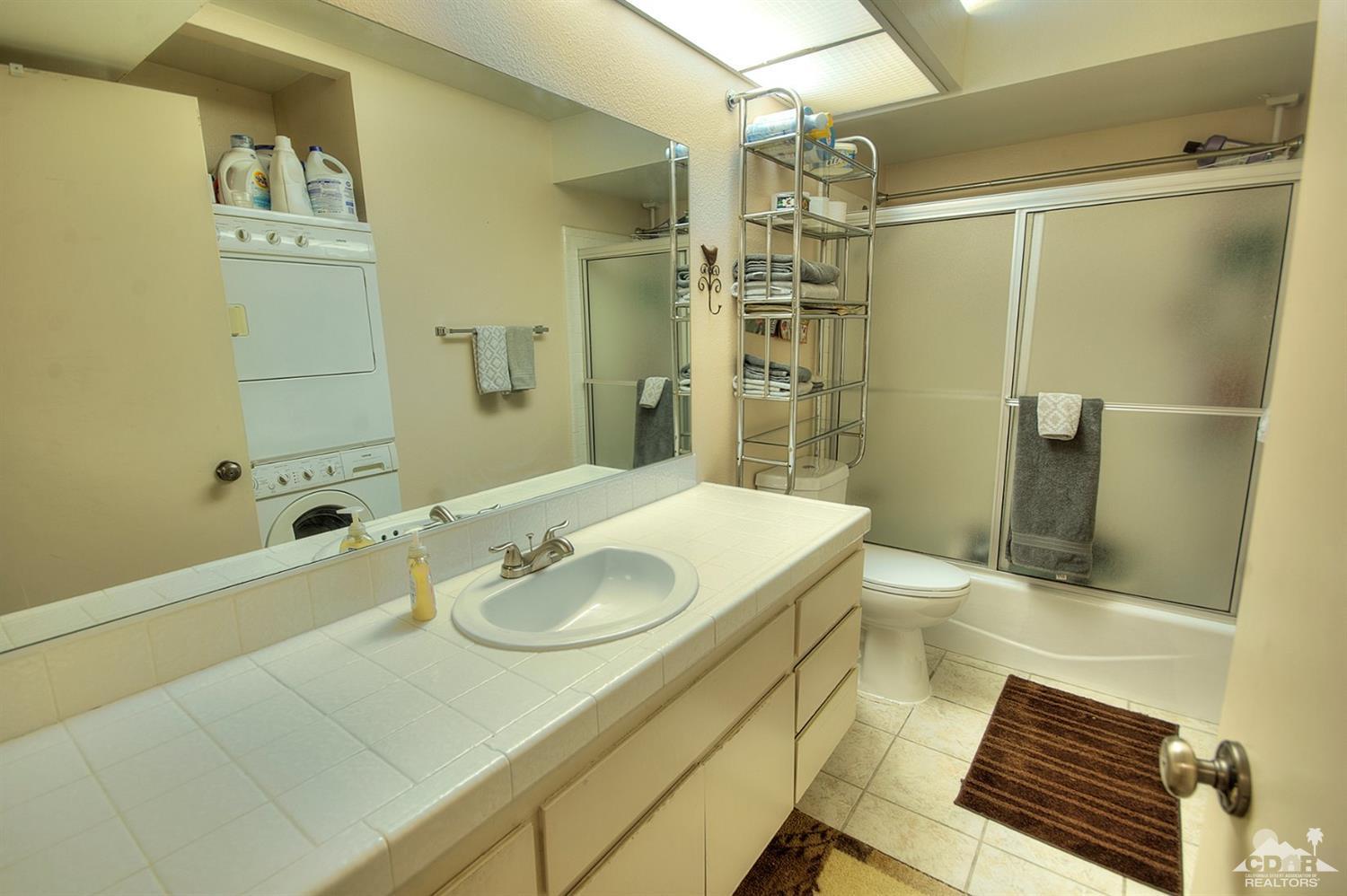 47395 Monroe Street, Unit 191 Indio, CA 92201 - Photo 15 of 21 a bathroom with a granite countertop sink a toilet and shower